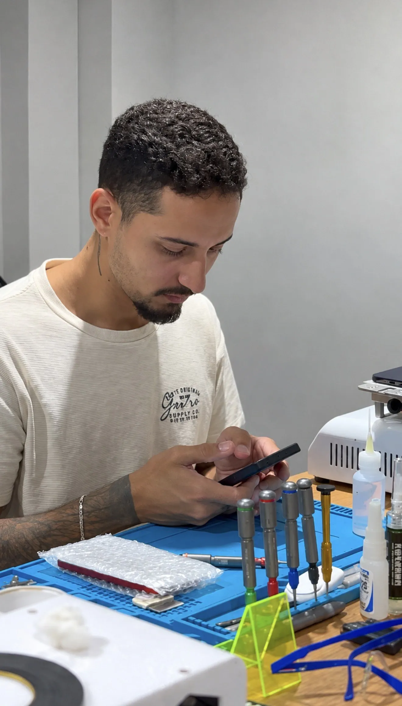 Técnico da iPhone Store DF consertando um celular na bancada